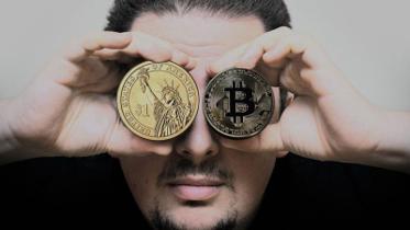 Man holding Bitcoin and US dollar coin – IRS cryptocurrency tax guidance