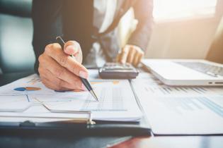 Form 5472 filing requirements for US LLC owners with hand reviewing financial report